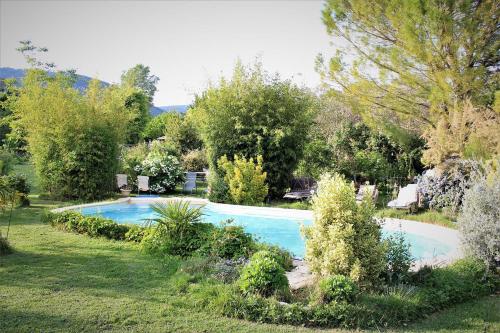 una piscina en un jardín con árboles y arbustos en Gites le Pimayon, en Manosque