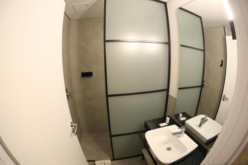 a bathroom with a sink and a mirror at Naalt Hotel Joinville in Joinville
