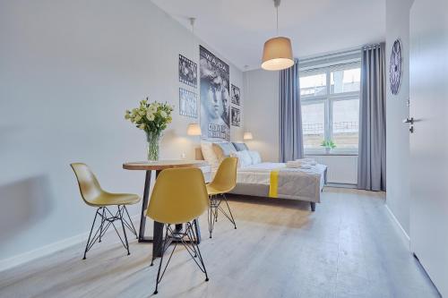 sypialnia z łóżkiem, stołem i krzesłami w obiekcie FLORIANSKA 32 by PI Apartments w Krakowie