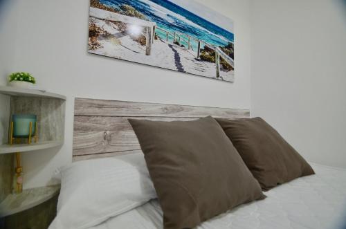 a bed with two pillows and a picture on the wall at 52 Luxury Pool - AC/WIFI in La Mata