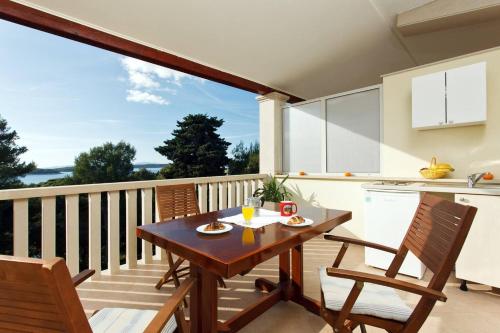 a balcony with a wooden table and chairs at Villa Malisko in Hvar