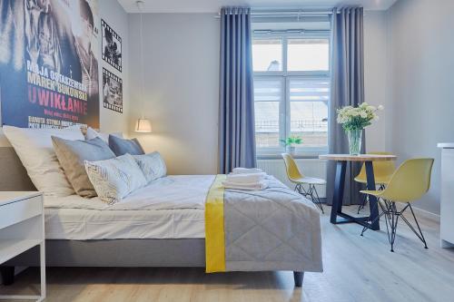 1 dormitorio con 1 cama, mesa y sillas en FLORIANSKA 32 by PI Apartments en Cracovia