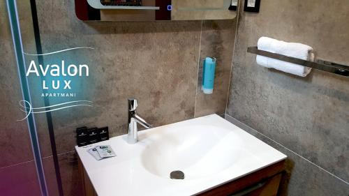 Un baño con un lavabo blanco en una habitación. en Avalon Lux Studio Apartment, en Novi Sad