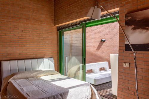 Schlafzimmer mit einem Bett und einem großen Glasfenster in der Unterkunft Villa delle Ortensie in Tavagnacco