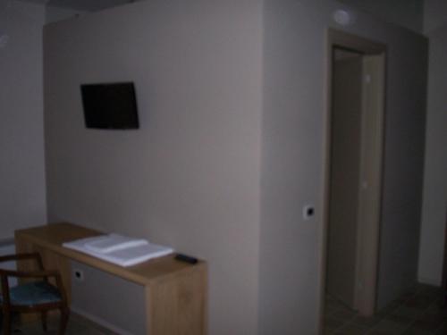 a room with a desk and a television on a wall at Agriturismo Battibue in Fiorenzuola dʼArda