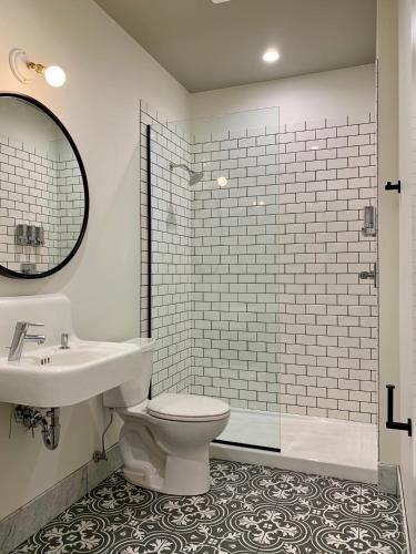 a bathroom with a toilet and a sink and a mirror at Norblad Hotel in Astoria, Oregon