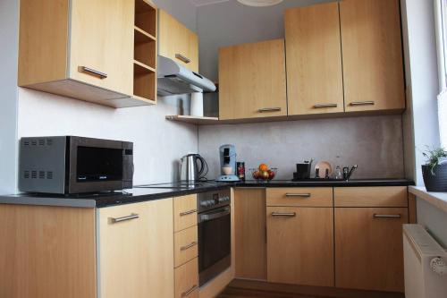 une cuisine avec des armoires en bois et un micro-ondes dans l'établissement Mieszkanie na uboczu Dobrzeń Wielki, à Dobrzeń Wielki