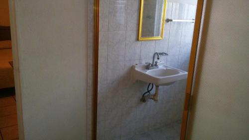 y baño con lavabo y espejo. en Casa Celia en Morelia
