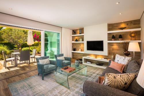 a living room with a couch and chairs and a television at Vila Balaia - Luxury Boutique Villas in Albufeira