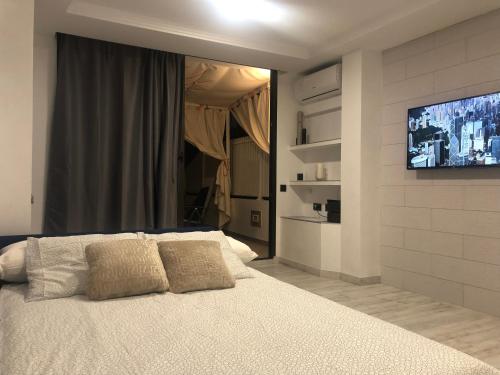a bedroom with a bed and a flat screen tv at MAGUI´S PLACE in Playa del Ingles