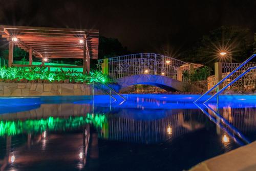 a bridge over a pool at night at Pousada Villa Real in Areia