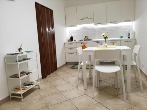a kitchen with a white table and white chairs at La Casa di Bianca in Caltagirone