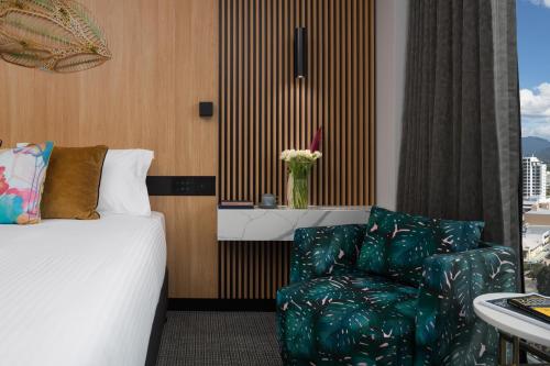 a hotel room with a bed and a chair at Crystalbrook Bailey in Cairns