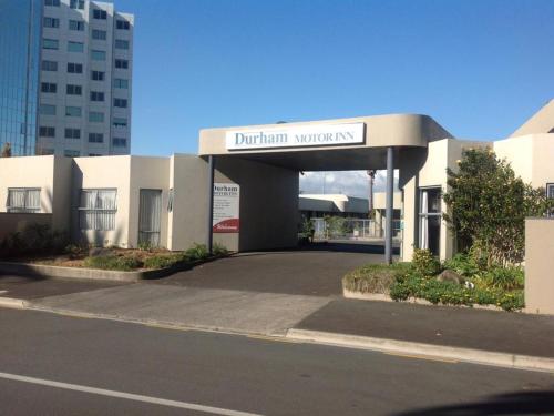 a building with a sign that reads durham university at Durham Court Motor Inn in Tauranga