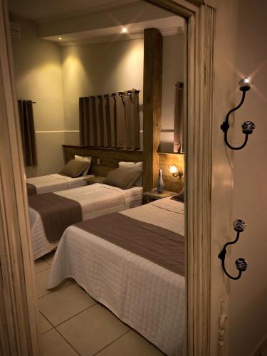 a bedroom with two beds and a mirror at Pousada Villa Real in Areia