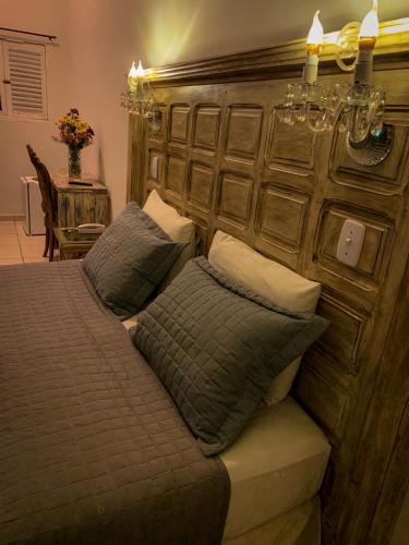 a bedroom with a bed with a wooden headboard at Pousada Villa Real in Areia