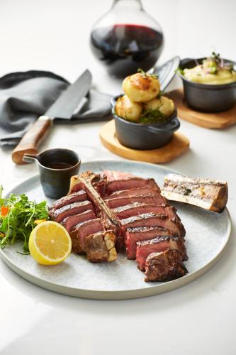 a plate of meat with a slice of lemon and other foods at Crystalbrook Bailey in Cairns