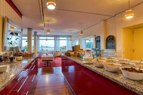a large room with a counter with bowls of food at FF&E Hotel Dania in Puttgarden