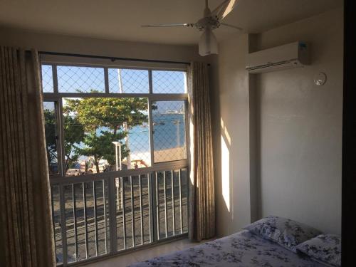 a bedroom with a window with a view of a beach at Apartamento Fortaleza - Beira Mar - Mucuripe in Fortaleza