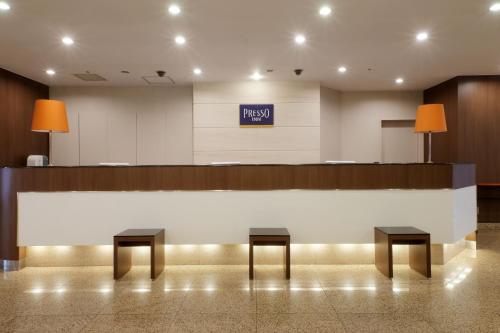 um átrio com uma área de espera com dois bancos em Keio Presso Inn Kanda em Tóquio