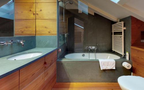 a bathroom with a tub and a sink at Duos Sours in Celerina