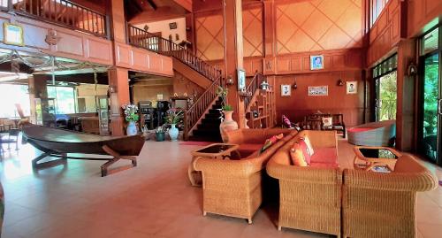 a living room with couches and chairs and a staircase at Andamanee Boutique Resort Aonang Krabi - SHA Extra Plus in Ao Nang Beach