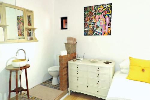 a bedroom with a bed and a toilet and a painting at Shells Cozy on-the-beach Hideaway in Sheffield Beach