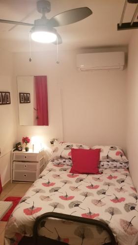 ein Schlafzimmer mit einem Bett mit einem roten Kissen in der Unterkunft Aché Tropical Studio@white-Red in San Juan