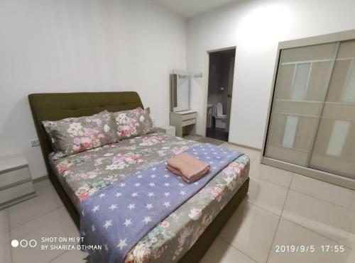 a bedroom with a bed with a blanket on it at Shah Suites Vista Alam in Shah Alam