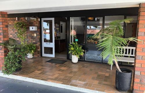 a front door of a building with potted plants at Matador Motor Inn in Coffs Harbour