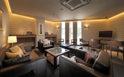 a living room with couches and a flat screen tv at Keio Presso Inn Otemachi in Tokyo