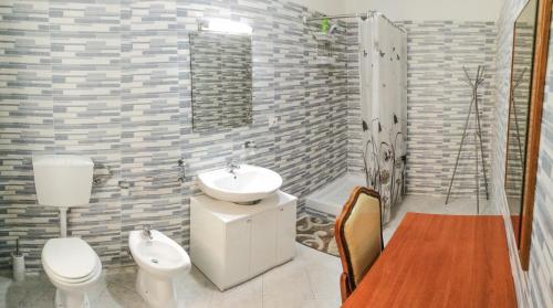 La salle de bains est pourvue d'un lavabo, de toilettes et d'une douche. dans l'établissement Metro Guest House, à Naples