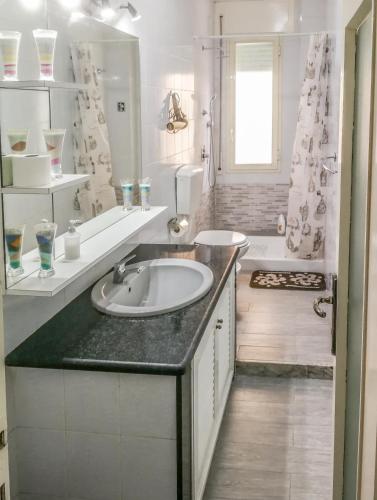 a white bathroom with a sink and a tub at Metro Guest House in Naples