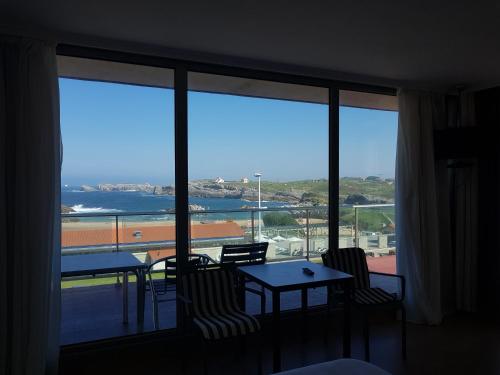 a room with a large window with a view of the ocean at Apartamentos Maradentro in Soto de la Marina