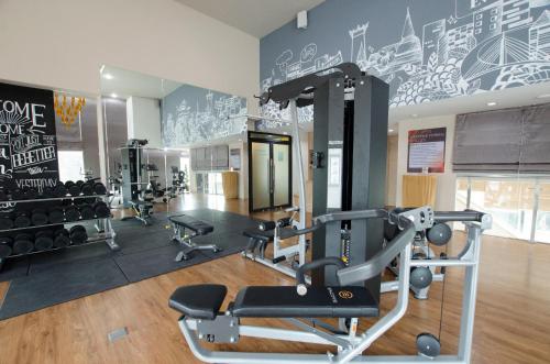 a gym with cardio equipment and a wall with graffiti at The Riche Boutique Hotel Don Mueang Airport in Bangkok