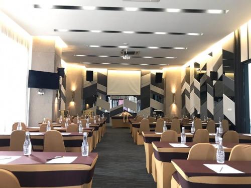 a dining room with tables and chairs and a screen at The Riche Boutique Hotel Don Mueang Airport in Bangkok