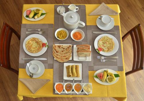 a table with plates of breakfast food on it at Villa 49 in Kandy