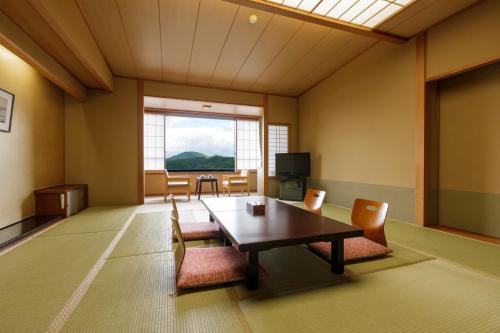a room with a table and chairs and a window at Hotel Shion in Morioka