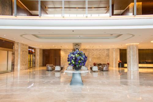 a lobby with a vase of flowers on a table at Golden Lake Hotel in Jinhu