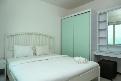 a bedroom with a white bed and a window at Nice 1BR Apartment at Thamrin Residence By Travelio in Jakarta