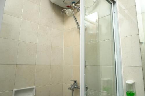 a shower with a glass door in a bathroom at Nice 1BR Apartment at Thamrin Residence By Travelio in Jakarta