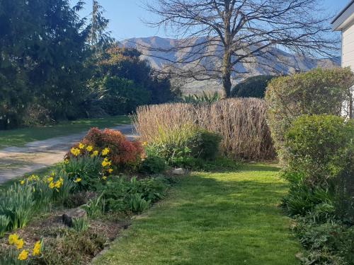 a garden with flowers in the grass next to a house at Windhaven Bed & Breakfast in Duntroon