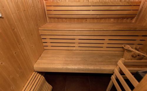 a wooden sauna with wooden stairs in a room at Hôtel Le Fabe in Paris