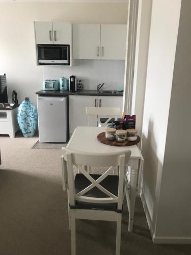 a kitchen with a white table and a white table and chairs at Broughton Views in Corlette