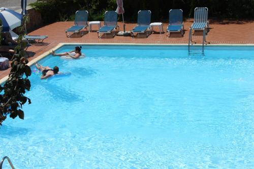 Dos personas están nadando en una piscina en Katerina Babis Studios, en Agios Prokopios