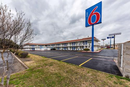 a sign for a gas station in front of a building at Motel 6-North Richland Hills, TX in North Richland Hills