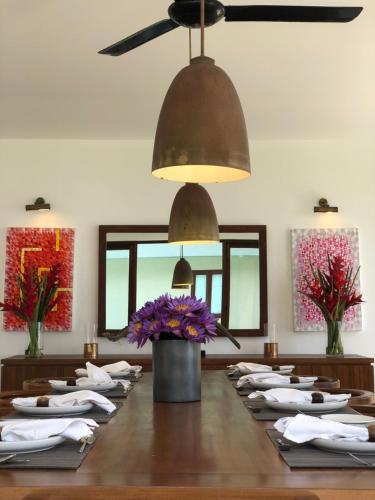 a dining room with a large table with white napkins at Jetwing Villa 700 in Bentota