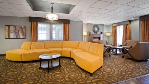 a living room with a yellow couch and chairs at Best Western Plus Coldwater Hotel in Coldwater