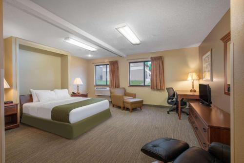 a hotel room with a bed and a desk at Days Inn by Wyndham Mitchell SD in Mitchell