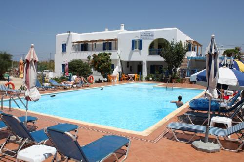 una gran piscina con sillas y sombrillas en Katerina Babis Studios en Agios Prokopios